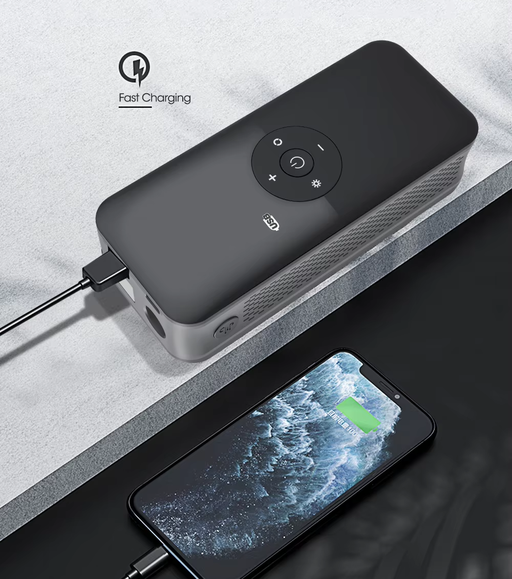 Black power bank with smartphone showing charging status on a gray surface